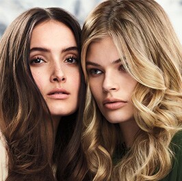 brunette woman with wavy hair and a blonde woman with curled hair
